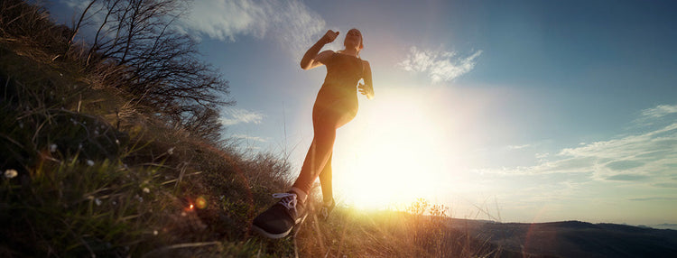 Woman going for a jog in the countryside at sunrise. 