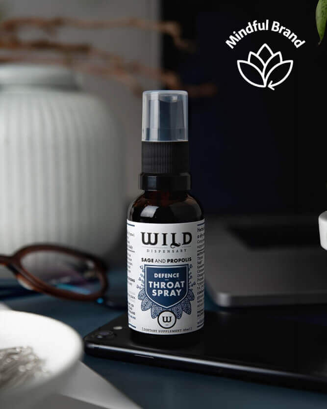 Throat spray bottle on a table with a blurred background.