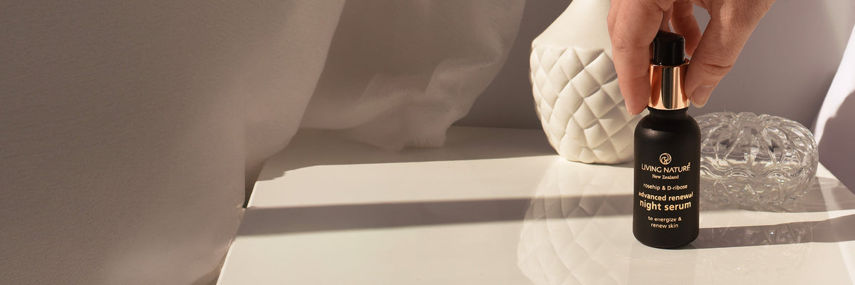 Living Nature Advanced Renewal Serum placed on a white bedside table with while design elements.