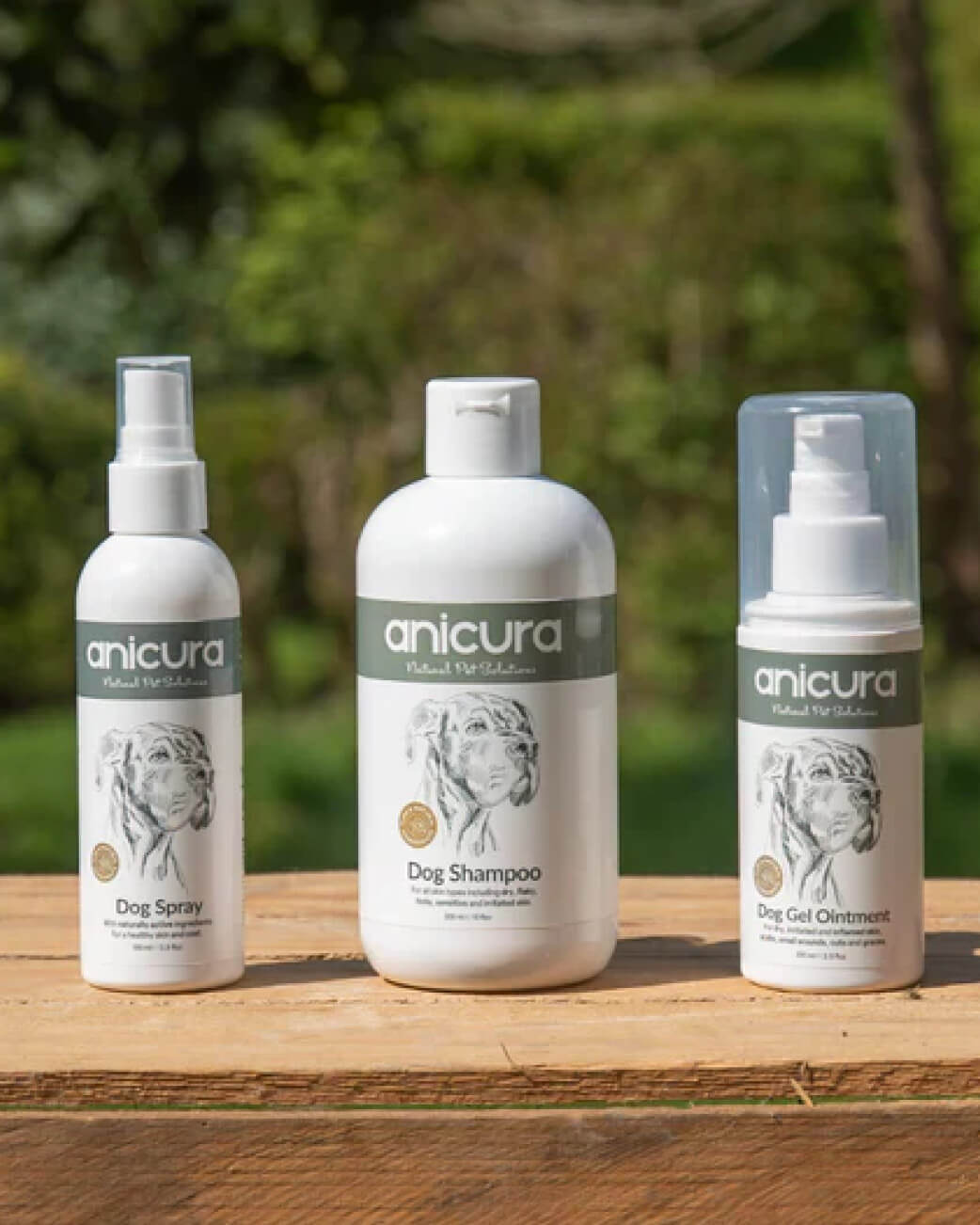 Three anicura pet care products on a wooden surface with a natural background