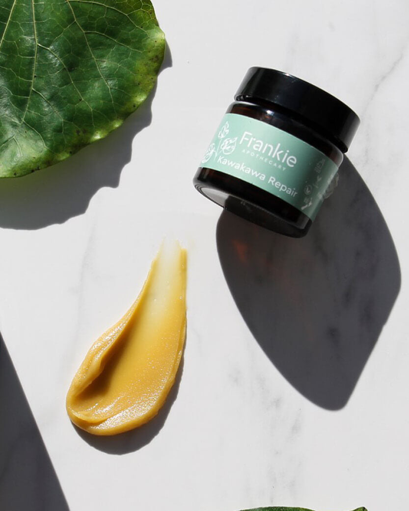 Jar of Frankie skincare product with a green leaf on a white background.