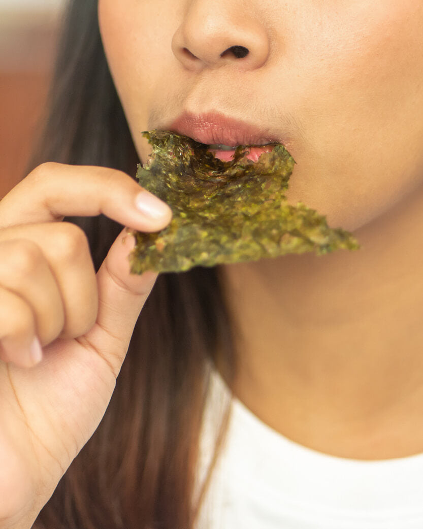 Person eating a seaweed snack.