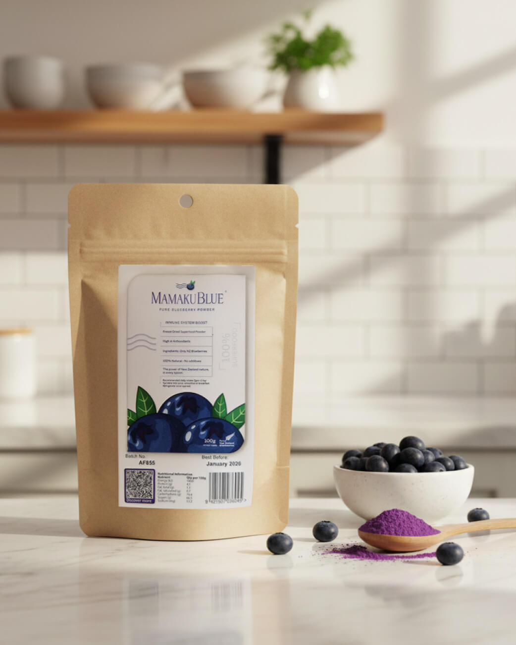 Mamaku Blue product packaging on a kitchen counter with blueberries and a spoonful of powder.
