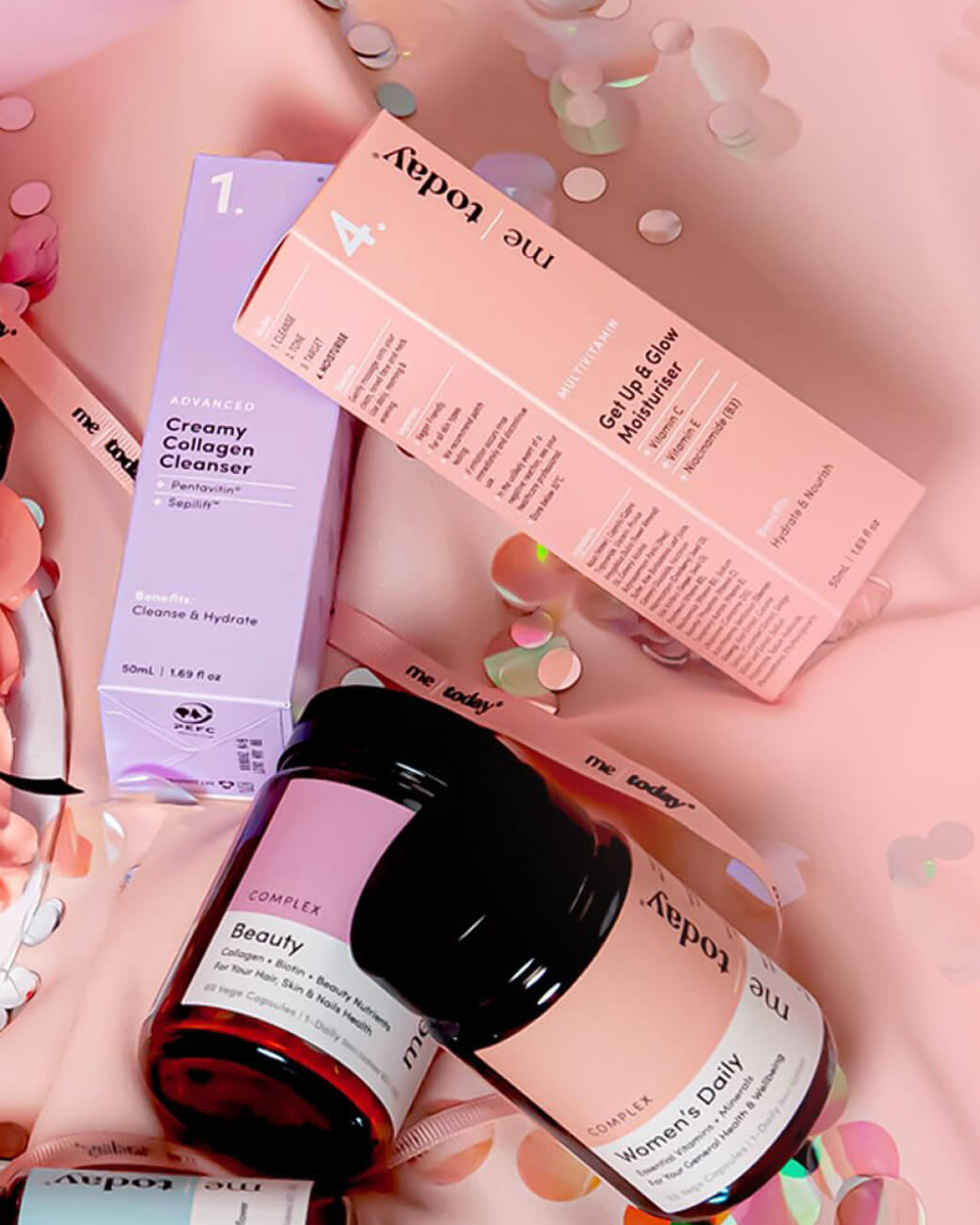 Cosmetic products and packaging on a pink background with confetti.