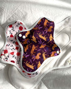 Two reusable menstrual pads with different patterns on a white background.
