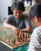 Woman and child playing chess together.
