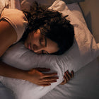 Woman lying on a pillow in a dimly lit room.