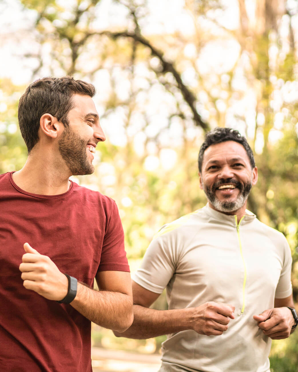 Two men jogging outdoors with a blurred natural background.