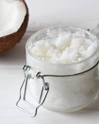 coconut oil and flakes in a glass jar on a white background