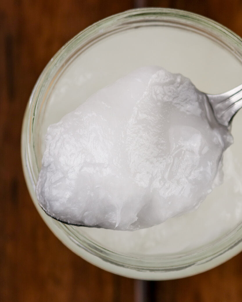 Jar of coconut cream with a spoonful being lifted out