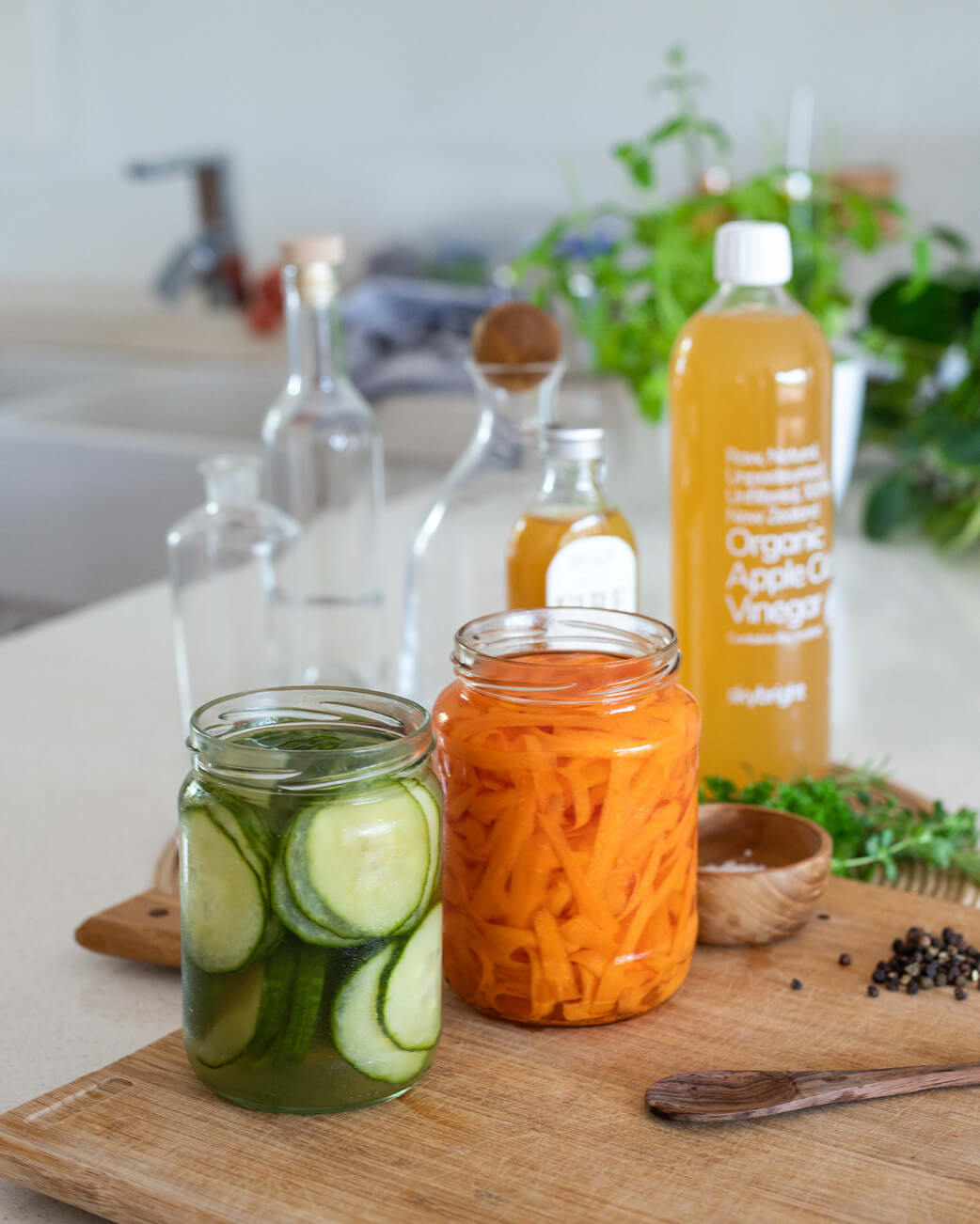 Sliced carrots and cucumbers in a jar on a chopping board.