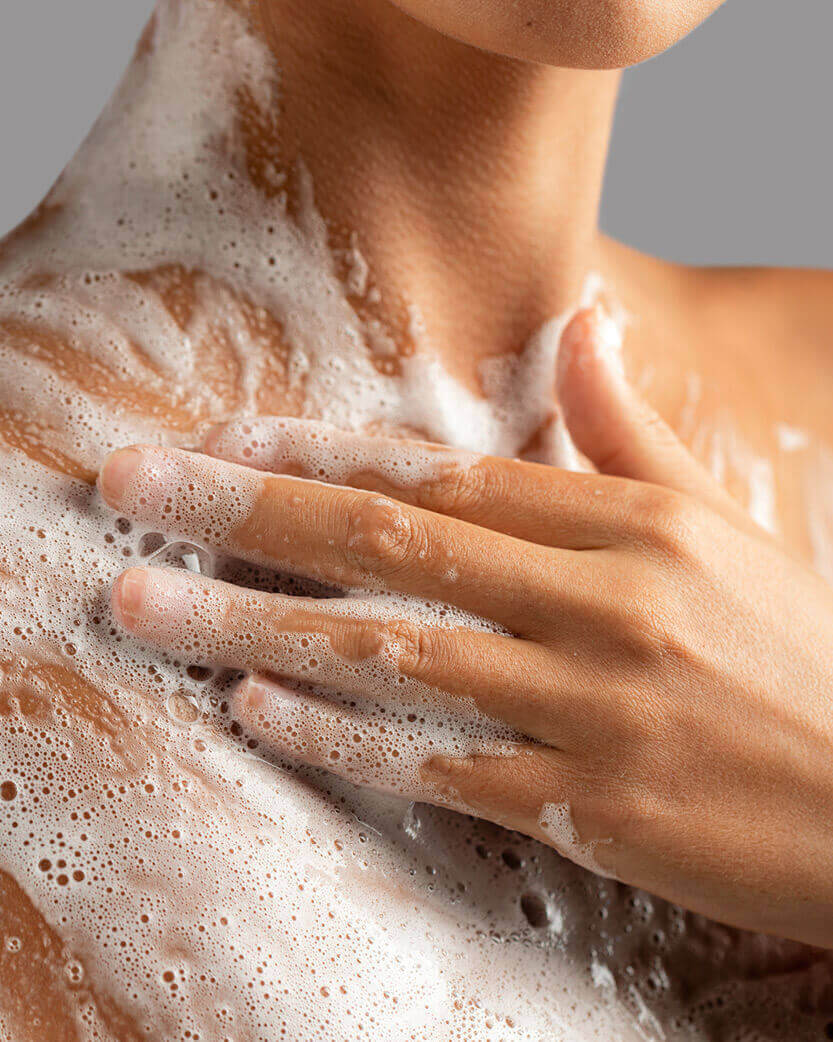 Person washing their neck with soap & water.