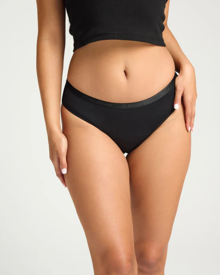 Person wearing black high-waisted underwear on a plain background.