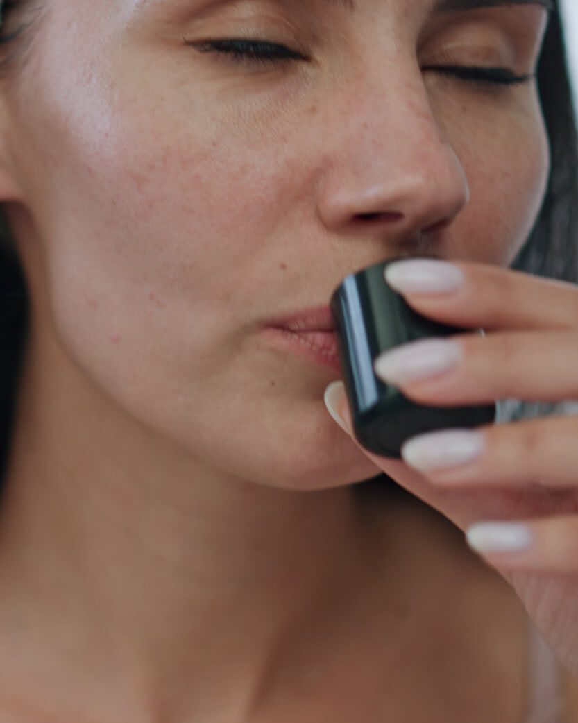 Woman with a close-up focus on her lips & hand.