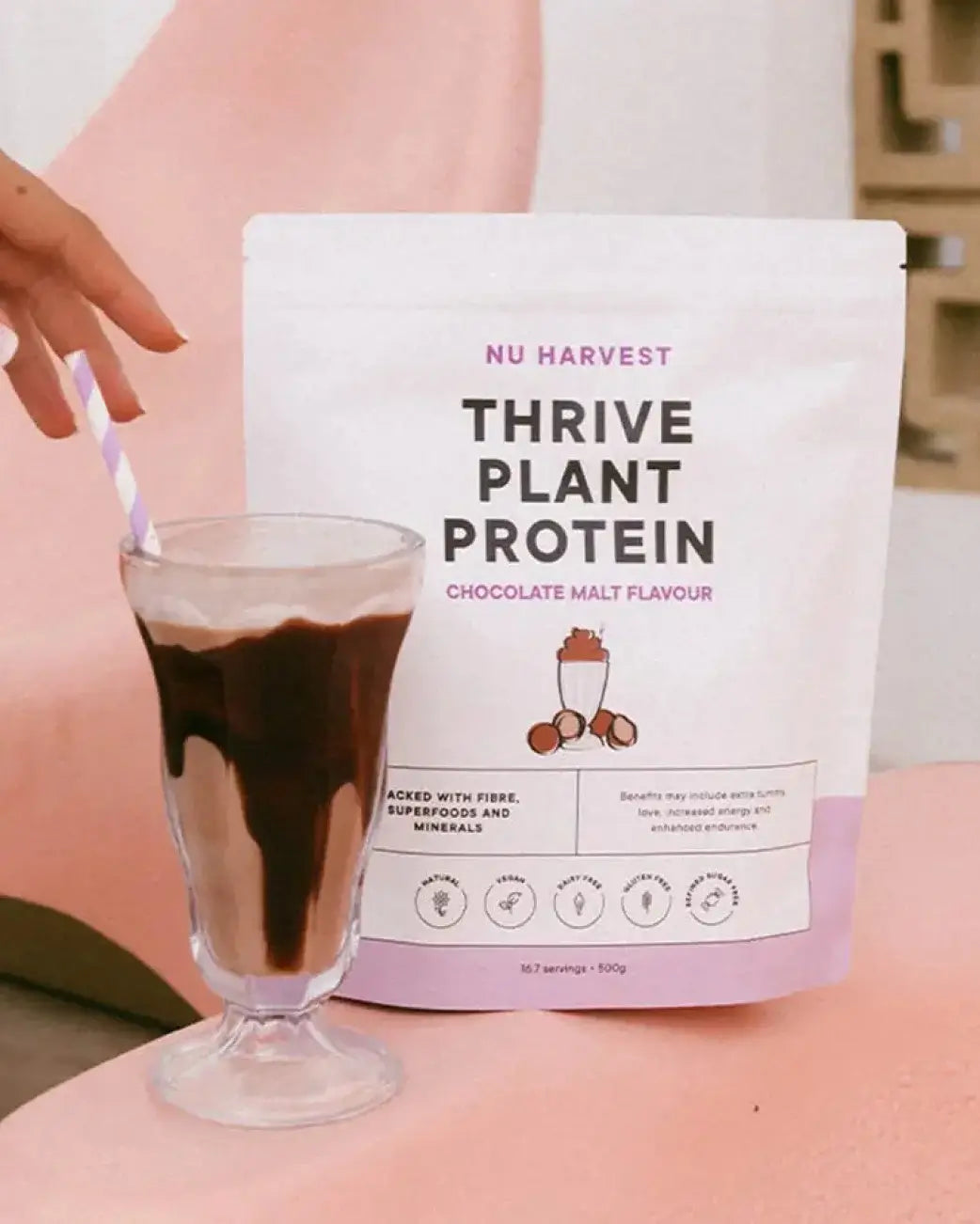 Nu Harvest Thrive Plant Protein package with a glass of chocolate malt protein shake.