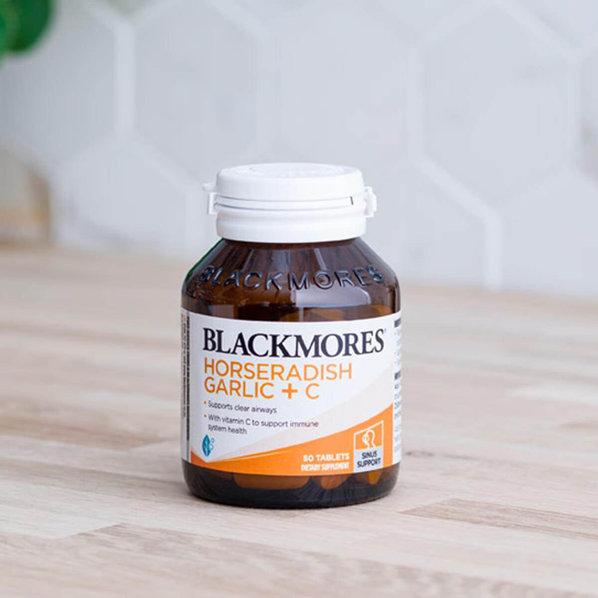 Blackmores Horseradish Garlic + C supplement bottle on a wooden surface.