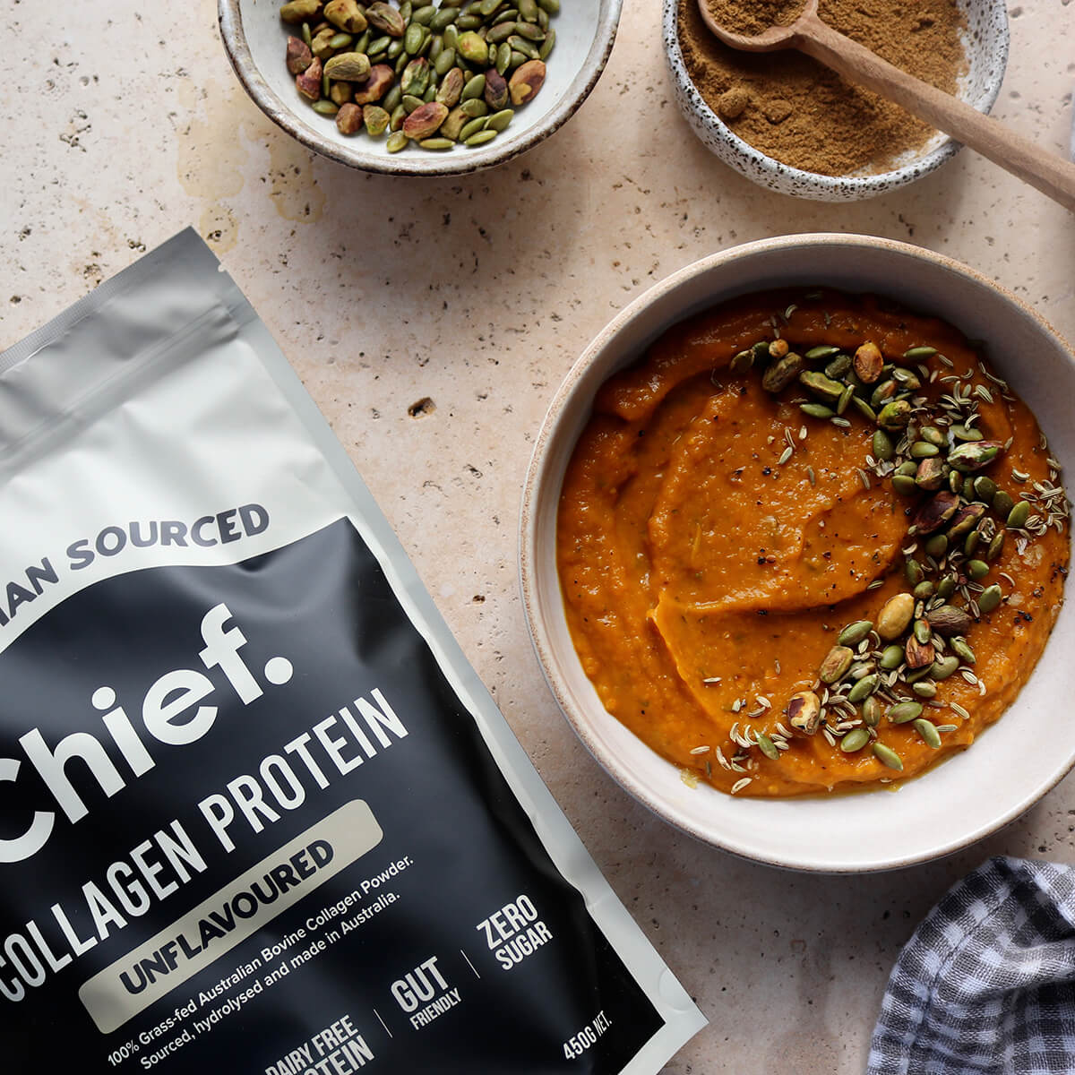 Collagen protein package with a bowl of soup and ingredients on a speckled surface.