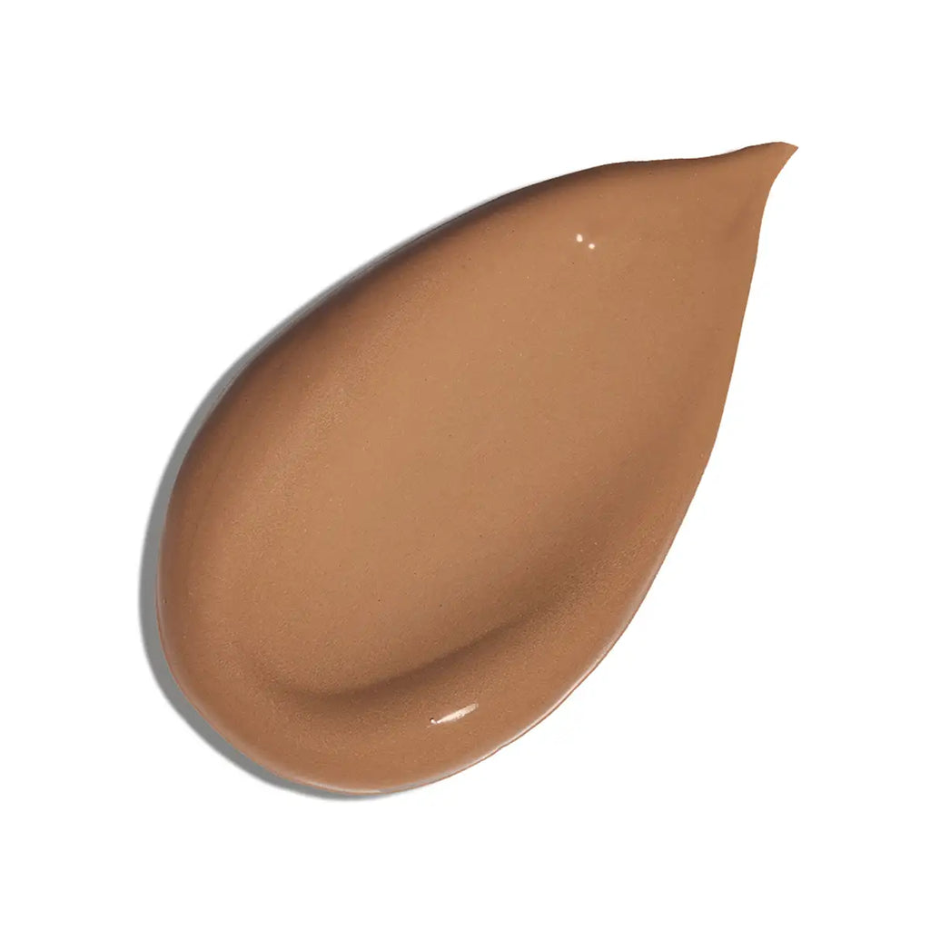 A teardrop-shaped smear of liquid foundation in a warm medium tan shade, shown on a clean white background.
