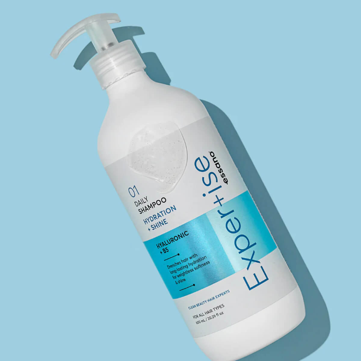 Expertise shampoo bottle on a light blue background.