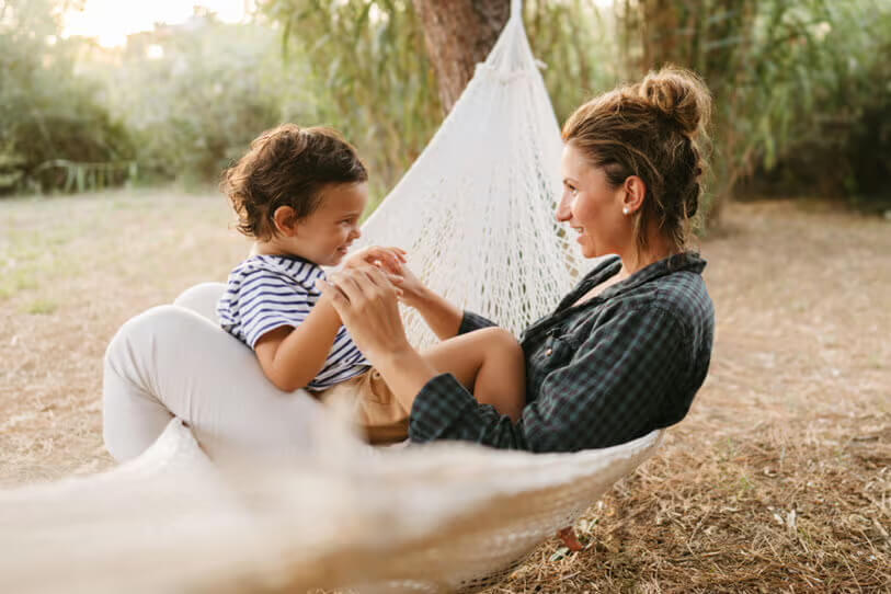 Mother and child sitting in a hammock together.
