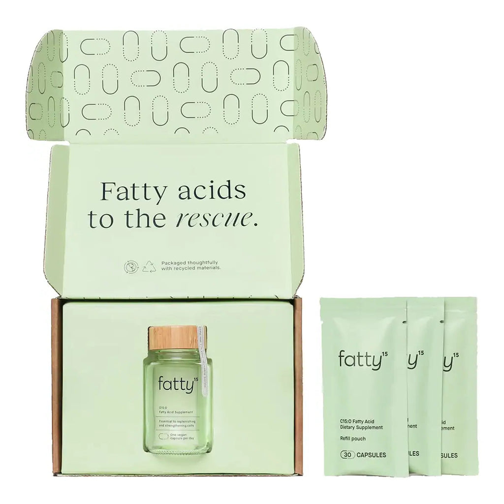 An open branded box containing a small supplement bottle with a bamboo cap and three sachets, all in a pale mint green colour.