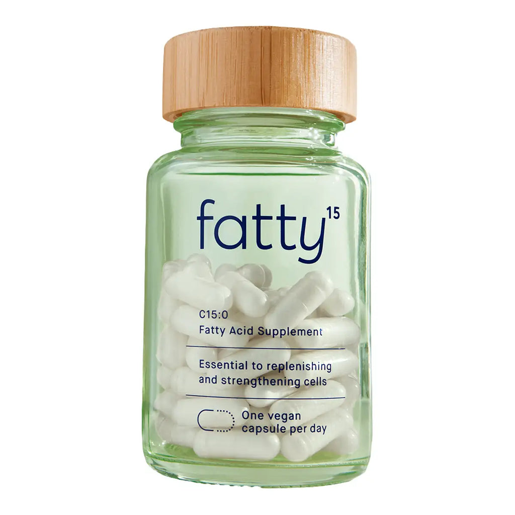 A clear glass bottle of C15:0 Fatty Acid Supplement with a light wood lid, containing white capsules.