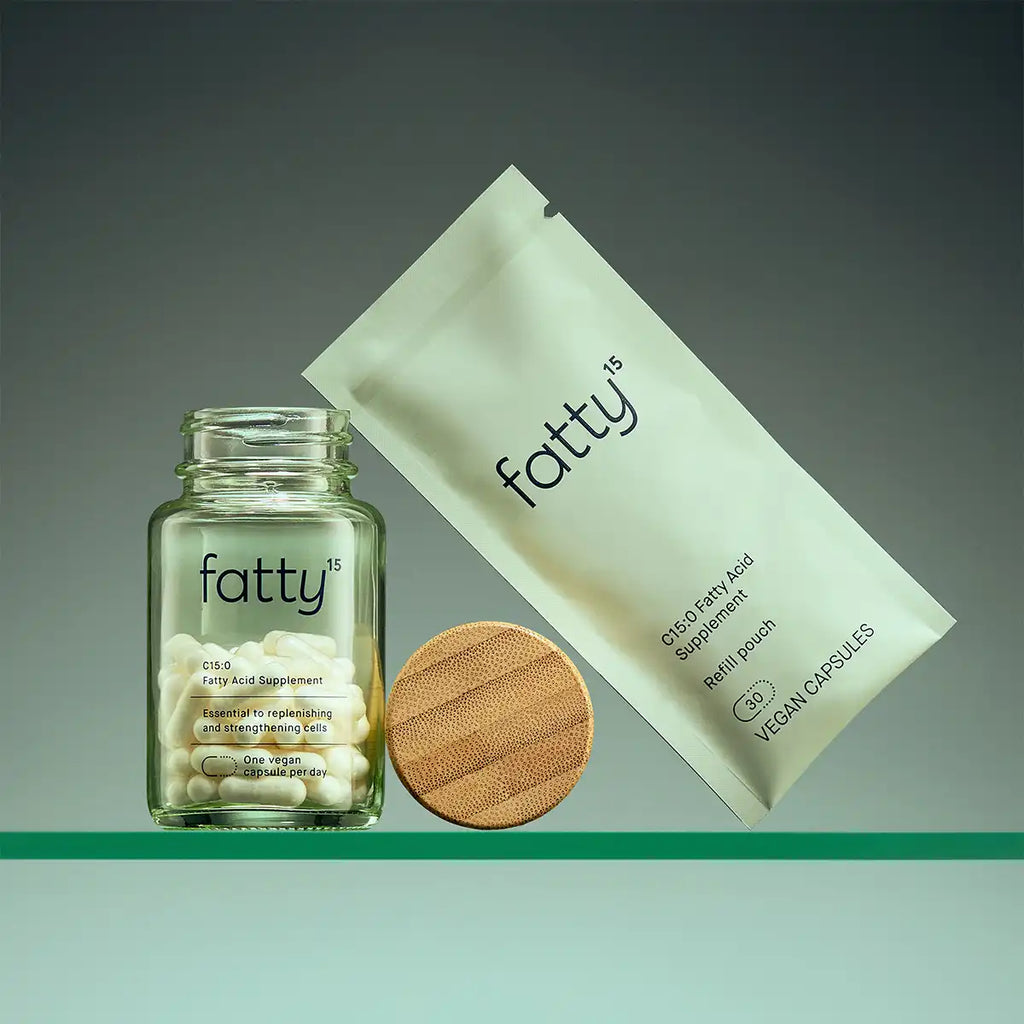 Fatty supplement bottle and light green pouch on a gradient background.