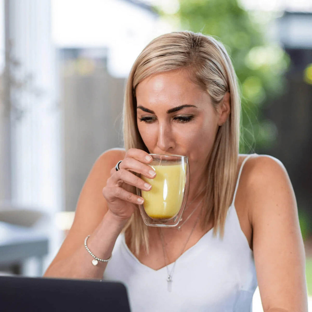 Woman drinking a cup of bone broth.