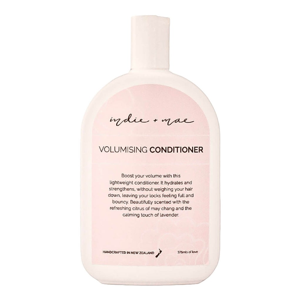 A 375ml bottle of Indie + Mac Volumising Conditioner, featuring a soft pink and white design with black text.