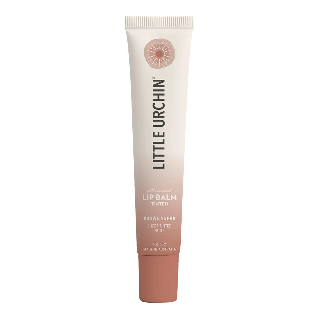 A tube of Little Urchin Lip Balm in the shade Brown Sugar, featuring a cream-to-rose gold gradient design with black text, set against a plain white background.