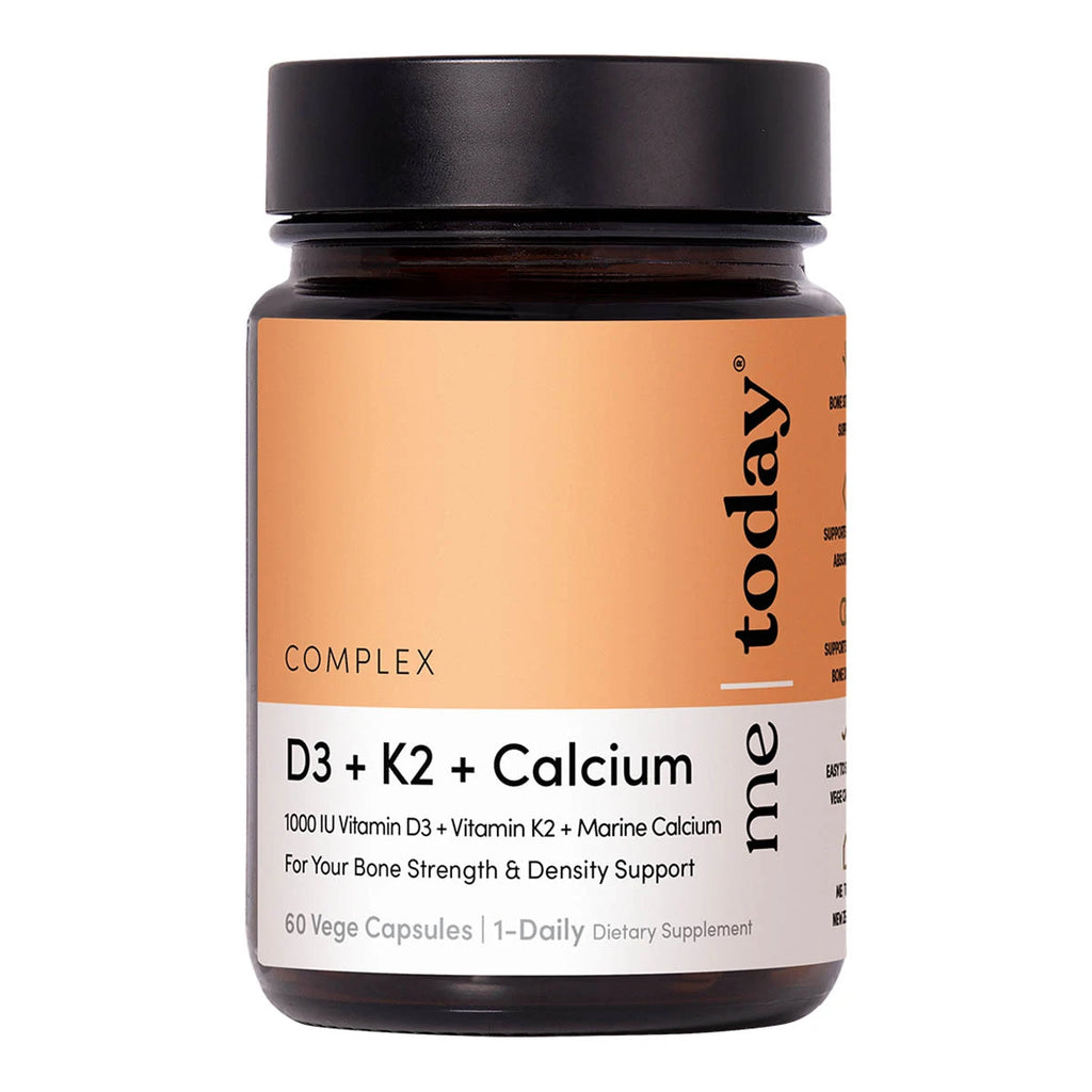 A bottle of 'me today' D3 + K2 + Calcium dietary supplement capsules, featuring a black cap and a peach and white label on a white background.