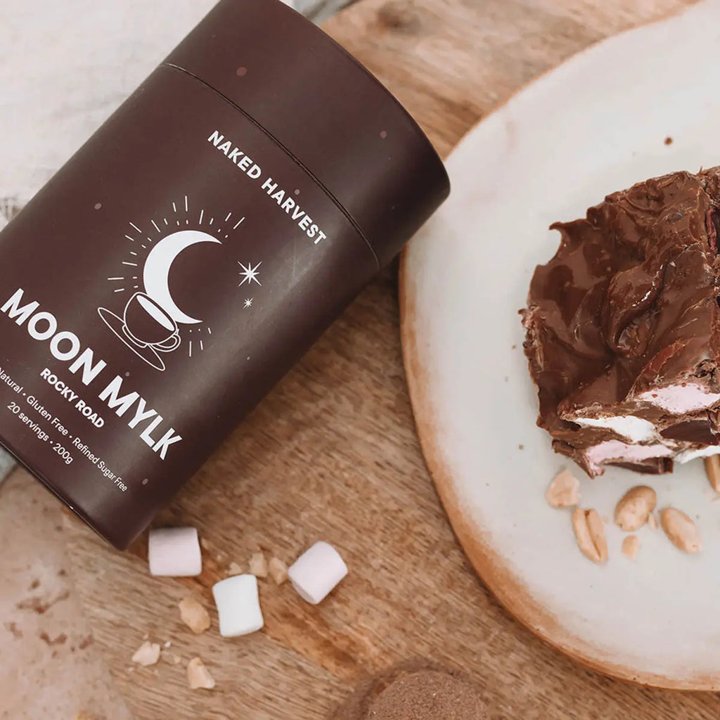Moon Mylk container on a wooden surface with a square of rocky road.
