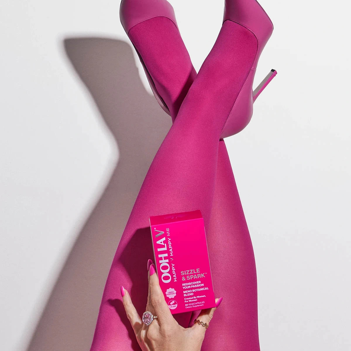 Pink high heels and Ooh La V product box on a white background. 